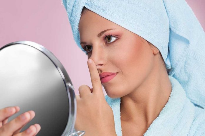Young,Woman,Holding,Mirror,And,Touching,Her,Nose 5 Beauty Tricks To Treat a Chapped Nose